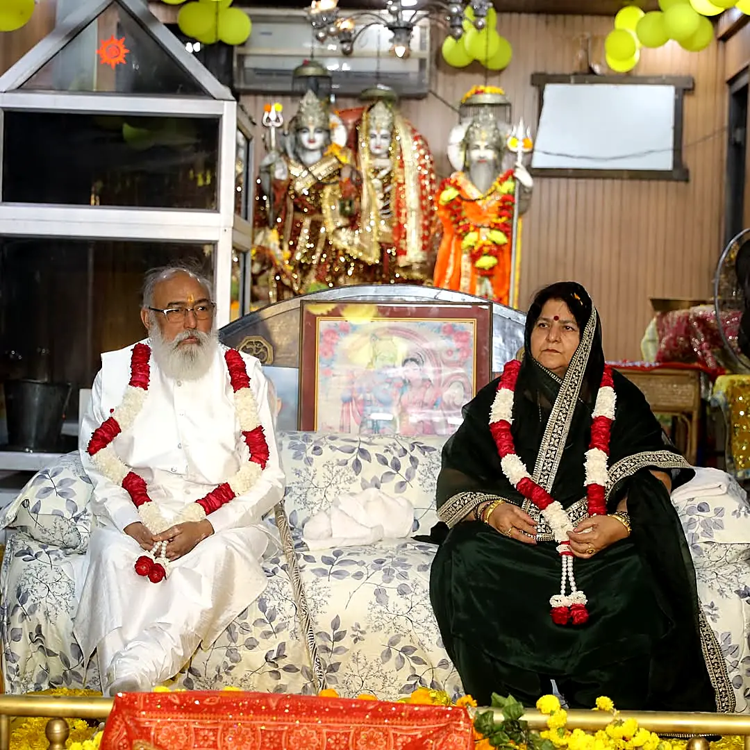 Guruji and Guru Maa garlanded before the temple darbar