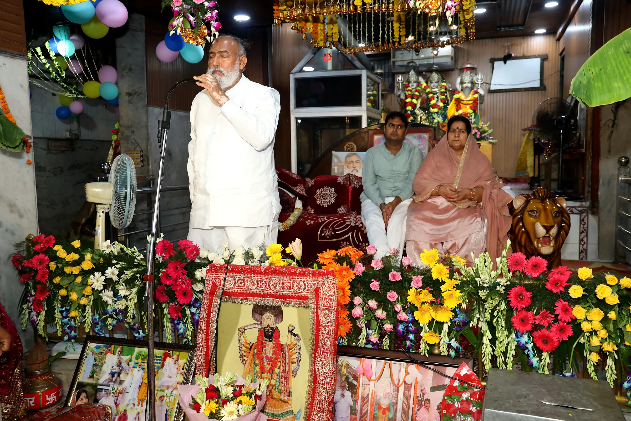 Guruji giving pravachan beside the flower-decked darbar