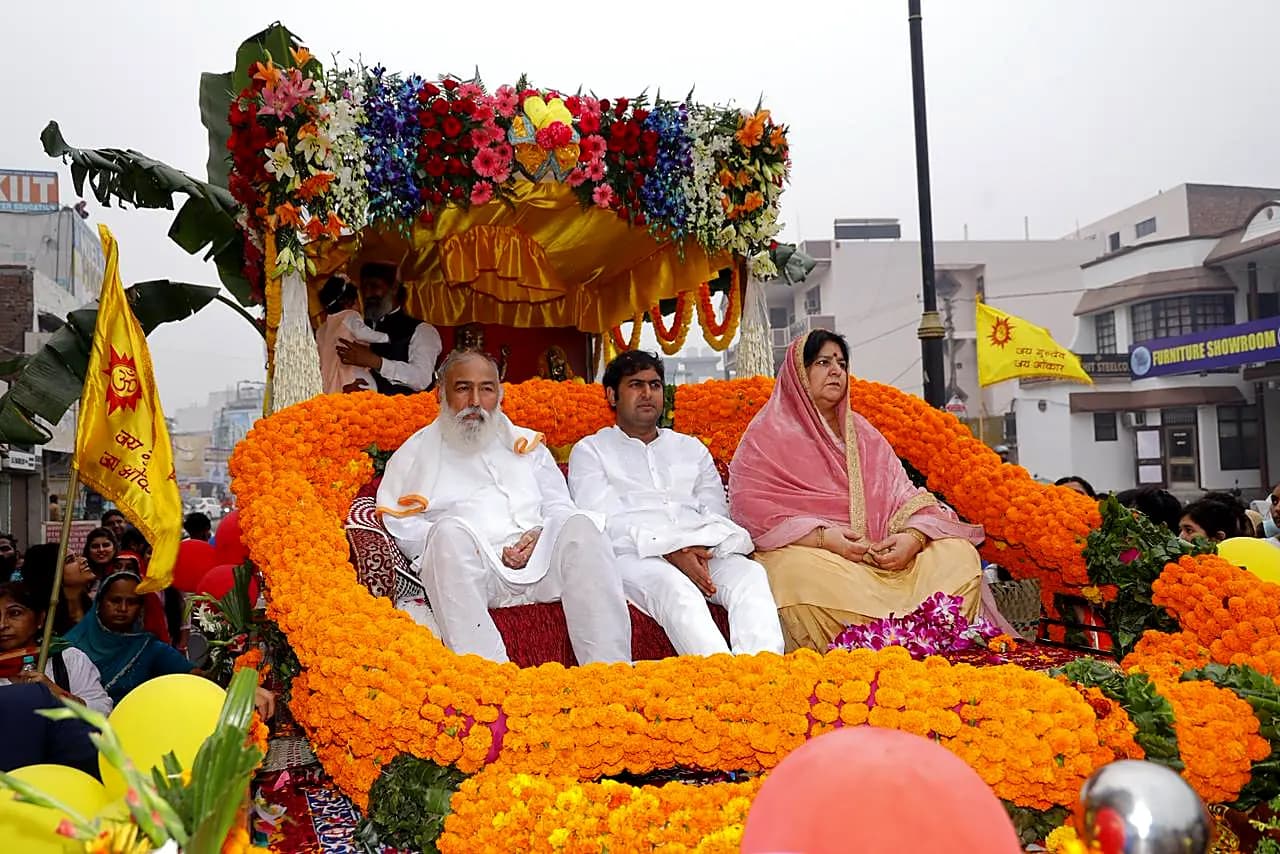 Guruji, Swami ji and Guru Maa on the marigold chariot of the shobha yatra