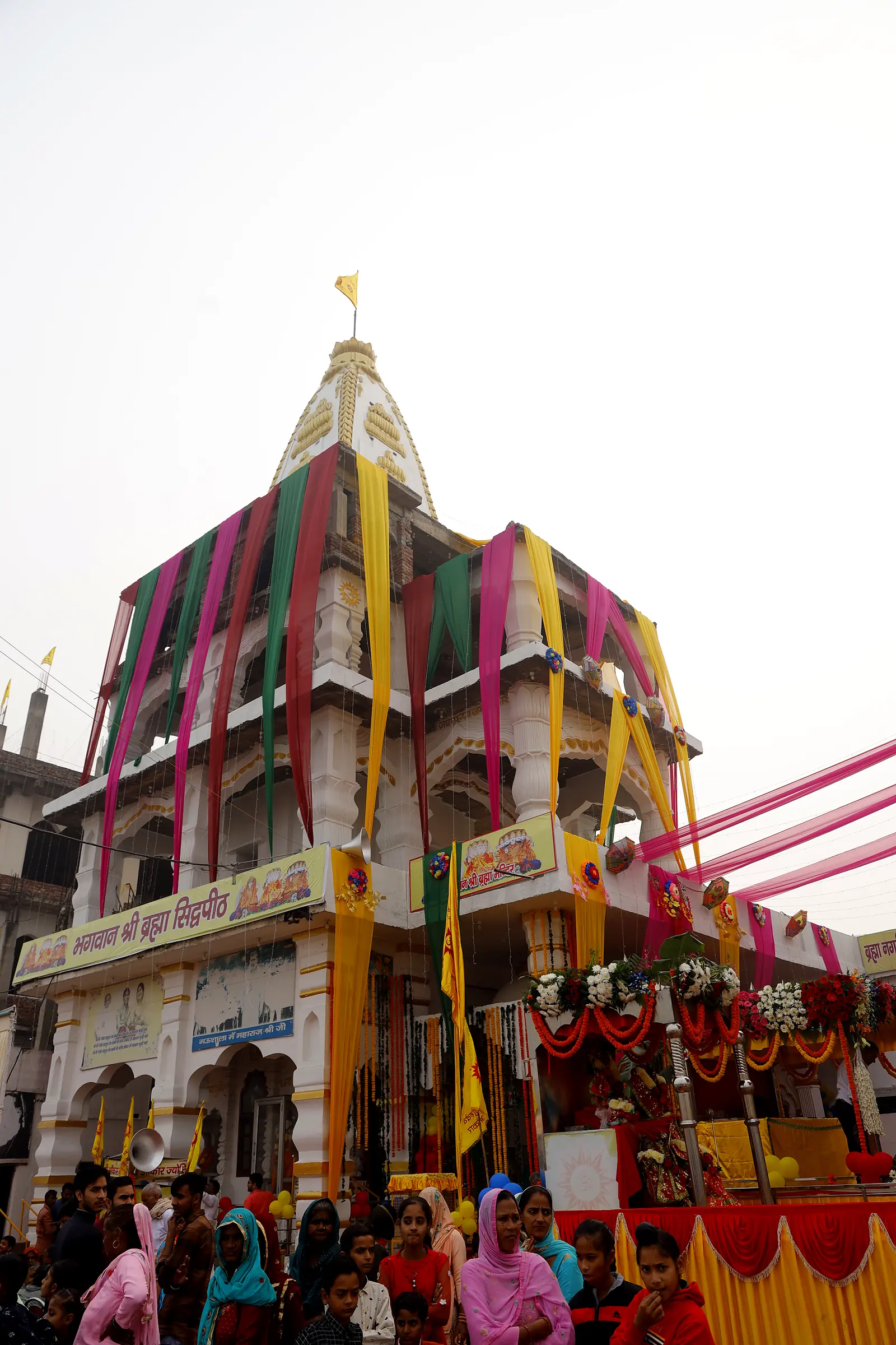 The temple dressed in festival drapes, filled with devotees